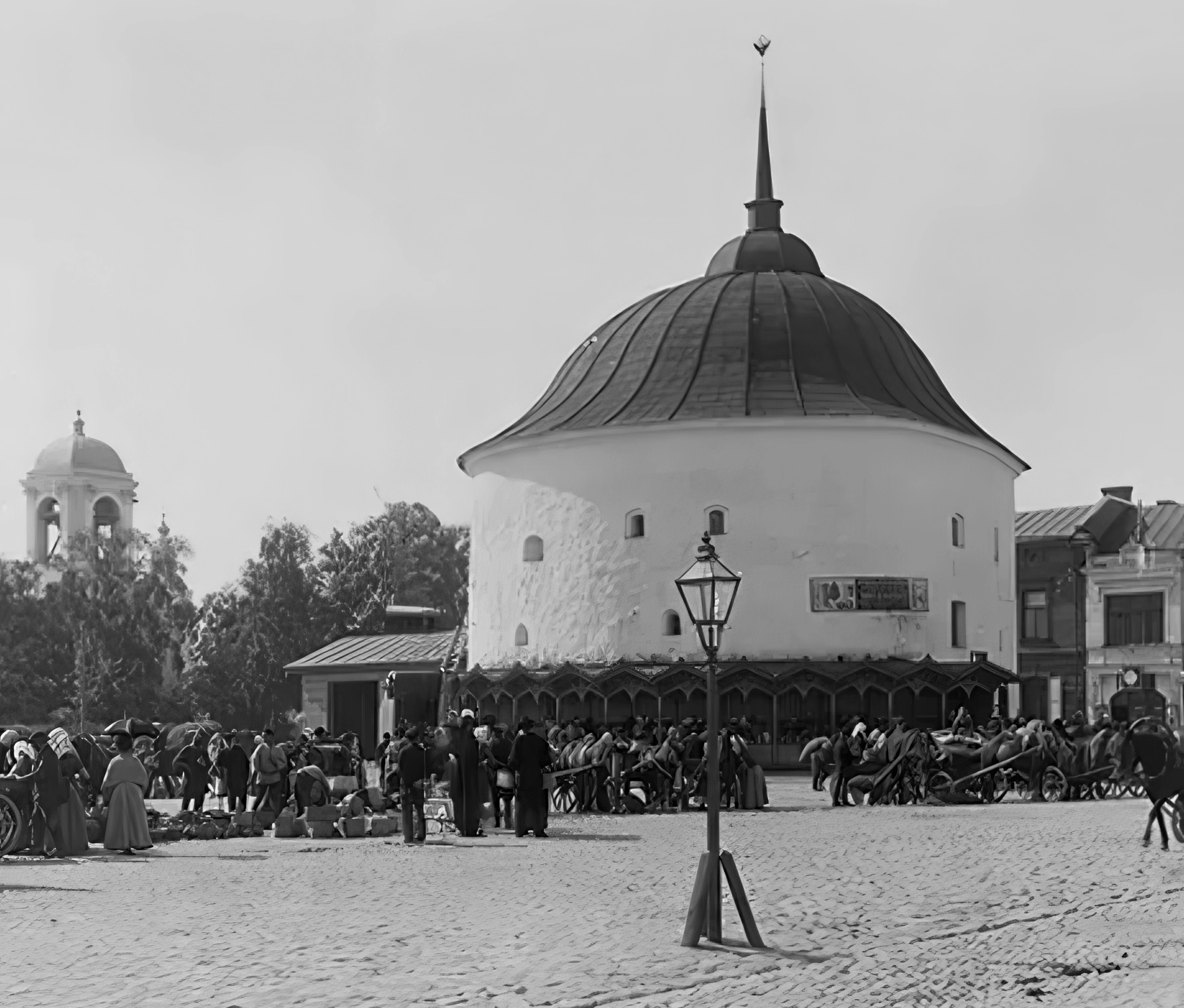 Old black-and-white photograph a gaslight pole on Vyborg market square in front of the Round Tower