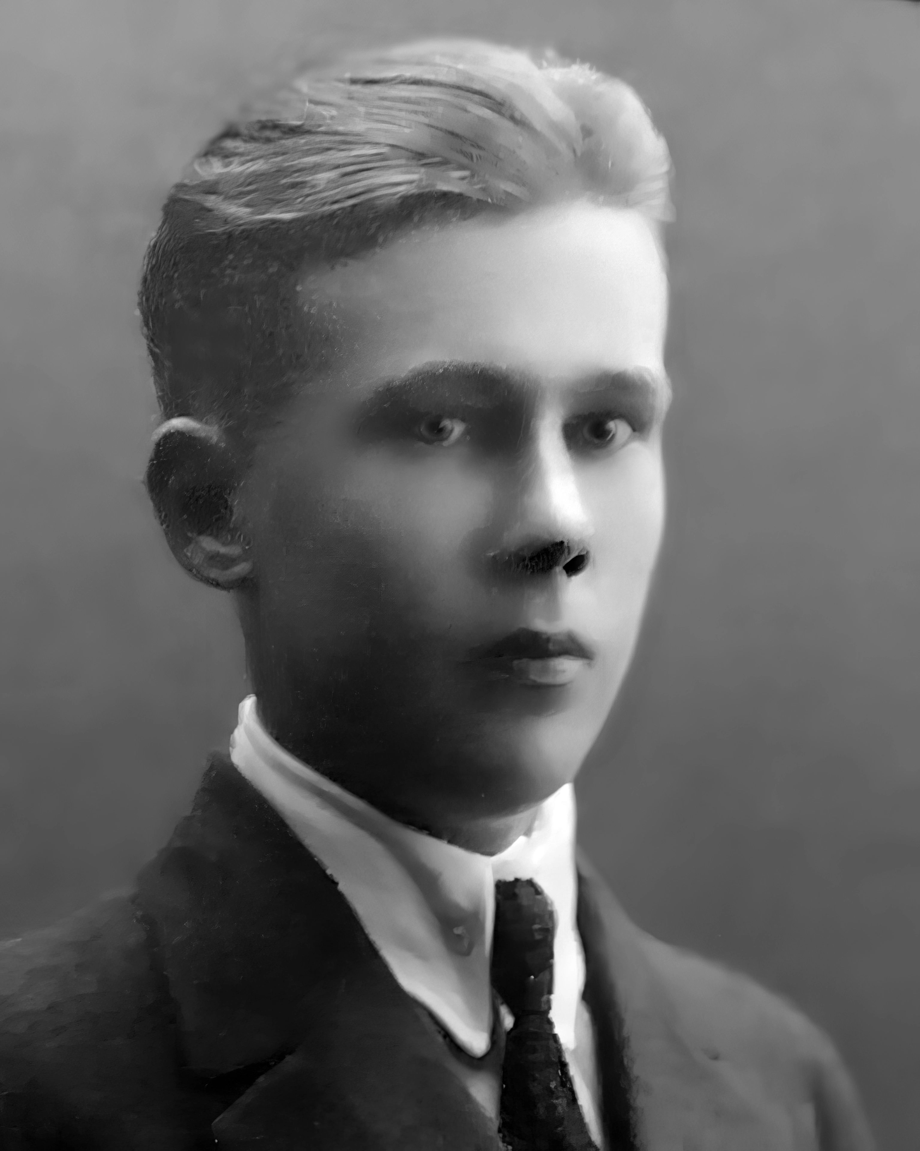 Old black-and-white photograph of a serious-looking young man in a suit